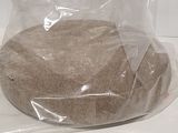 a bag of sand sitting on a counter next to a bottle of water