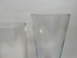 two glass vases sitting next to each other on a table
