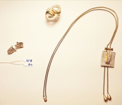a gold necklace and a pair of earrings on a table