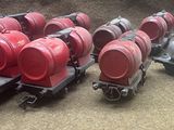several red barrels are lined up on top of a train car
