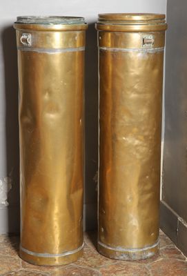 two tall gold vases sitting next to each other on the floor