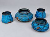 trois vases bleus posés les uns à côté des autres sur une table