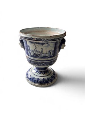 un vase bleu et blanc posé sur une surface blanche