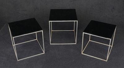 three black and silver side tables on a black background