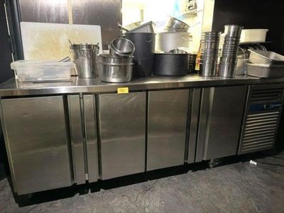 un plan de travail en acier inoxydable sur lequel sont posées des casseroles et des poêles