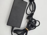 un chargeur noir et un câble posés sur une surface blanche