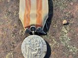 une médaille posée par terre à côté d'une pièce de monnaie