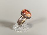 a silver ring with an orange stone in it