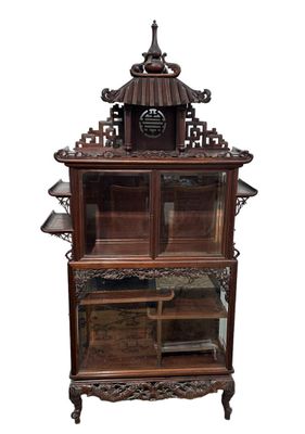 une vitrine en bois surmontée d'une horloge
