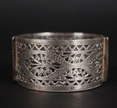gros plan d'une bague en argent sur une surface noire