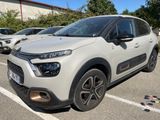La Citroën blanche est garée sur un parking, à côté d'autres voitures