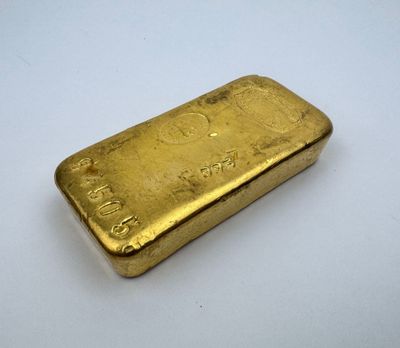 une barre d'or posée sur une surface blanche