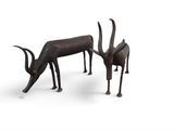 paire de sculptures d'antilopes en bronze sur fond blanc, avec un espace réservé à la légende