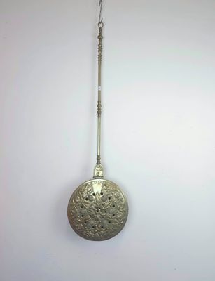 une cuillère en argent suspendue à un crochet fixé au mur