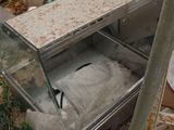 a broken refrigerator sitting on the ground next to a pile of trash