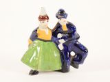 two figurines of a man and a woman standing next to each other