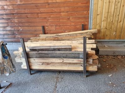 a pile of wood sitting on the ground next to a building