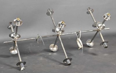 four metal objects are arranged in a row on a gray surface