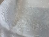 a close up picture of a white shirt with a lace pattern on it