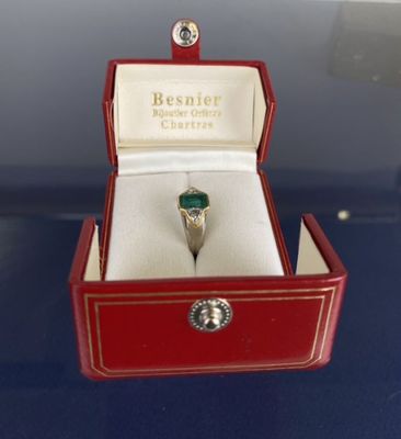 une boîte rouge posée sur une table, avec une bague à l'intérieur