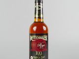 un gros plan d'une bouteille de vin rouge posée sur une surface blanche