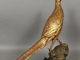 a golden bird sitting on top of a statue of a dog