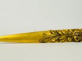 gold plated knife with a lion head and leaves on the blade