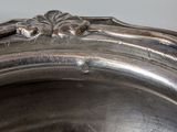 a close up of a silver plate with a bird on top of it