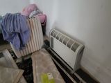une photo d'une chambre avec un radiateur et un lit