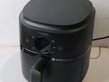 a black air fryer sitting on a counter top