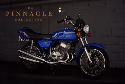 a blue motorcycle parked in front of a brick wall