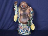 une statue représentant un homme qui rit, tenant une cuillère et une cuillère