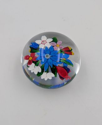 presse-papier en verre orné de fleurs et de feuilles sur fond blanc