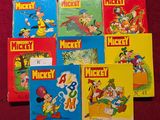 plusieurs livres de Mickey Mouse posés sur une surface rouge à côté d'une souris, d'une souris, d'une souris, d'une souris, d'une souris, d'une souris, d'une souris, d'une souris, d'une souris