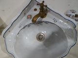 un évier blanc avec un robinet en or et un robinet en or
