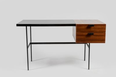 Le bureau est en bois et en métal, avec un plateau noir.