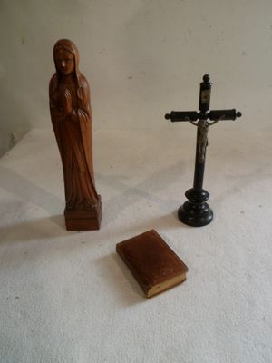a statue of a woman and a cross on a table