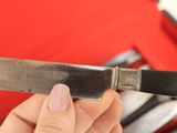 a person holding a knife in their hand in front of a tool box