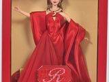 La poupée Barbie se trouve dans une boîte rouge et porte une robe rouge.