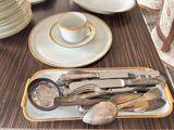 a tray of silverware on a table with a cup and saucer