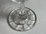 a glass of wine sitting on a table next to a glass of wine