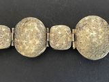 a close up of a silver bracelet with oval clasps