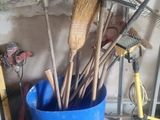 un seau bleu rempli de balais et d'autres outils