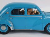 a blue toy car with a dog in the passenger seat