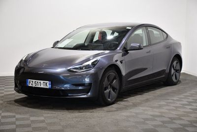 a grey tesla suv parked in a room with checkered floor