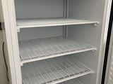 a white refrigerator that is open and empty in the room