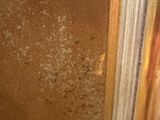 a toilet in a dirty bathroom with a dirty wall