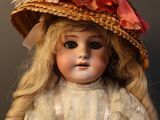 a doll that is wearing a hat and a dress