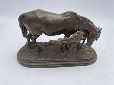 bronze statue of a horse and her foal on a wooden base