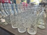 des bouteilles et des verres posés sur une table dans un magasin, avec une vitrine en arrière-plan